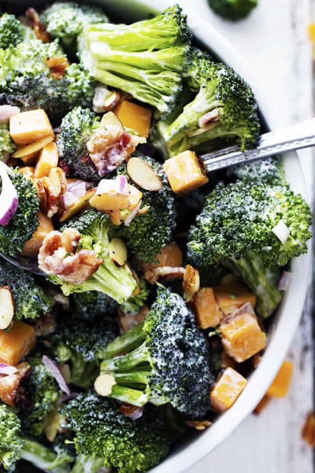 Creamy broccoli salad in a white bowl.