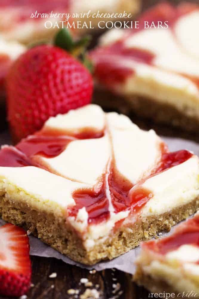 strawberry swirl cheesecake oatmeal cookie bar close up with a strawberry garnish.