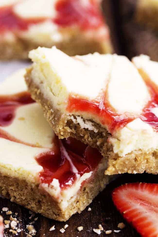 Close up of a strawberry swirl cheesecake bar with a bite taken out.