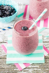 Blueberry Smoothie in a glass with a blue and white striped straw by Deliciously Sprinkled