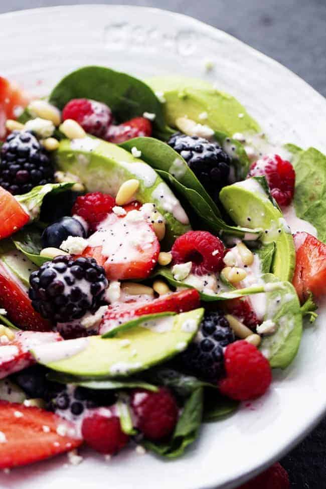 Close up of a berry salad on a white plate.