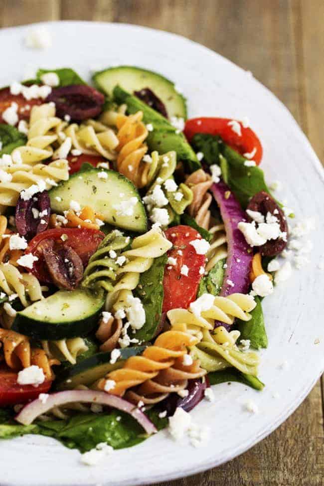 greek spinach pasta salad in a white bowl.