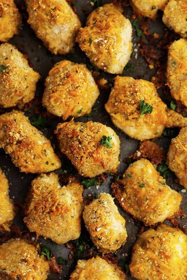 garlic parmesan cheddar chicken bites on a sheet pan.