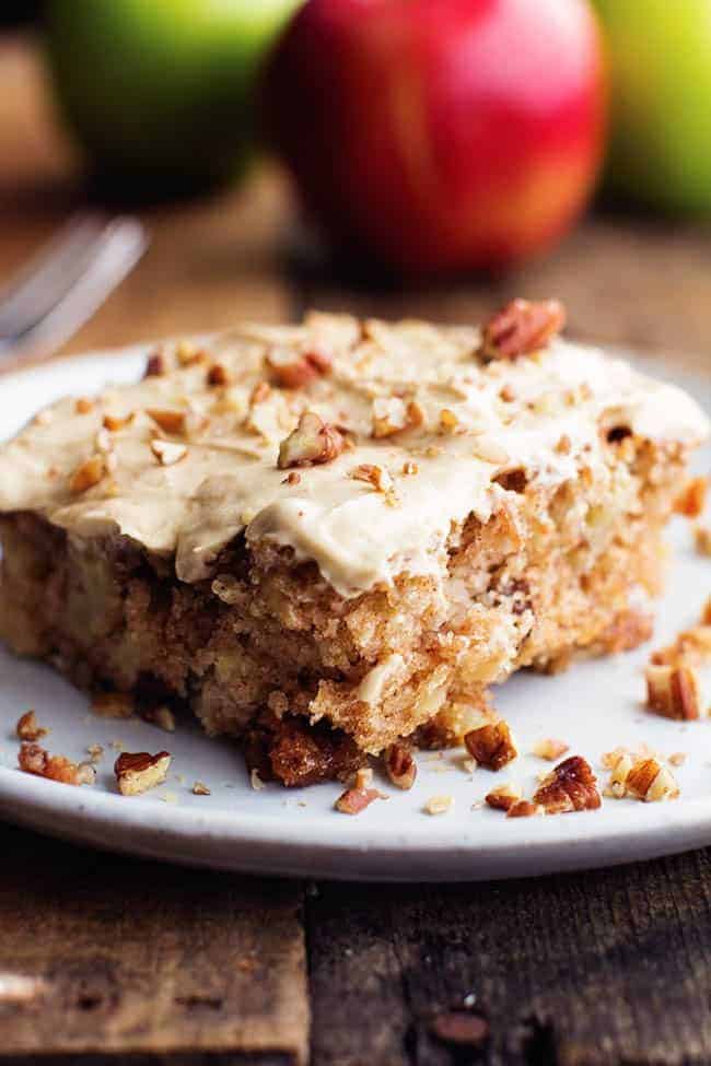 Apple Pecan Spice Cake with Brown Sugar Cream Cheese Frosting side view on a white plate.