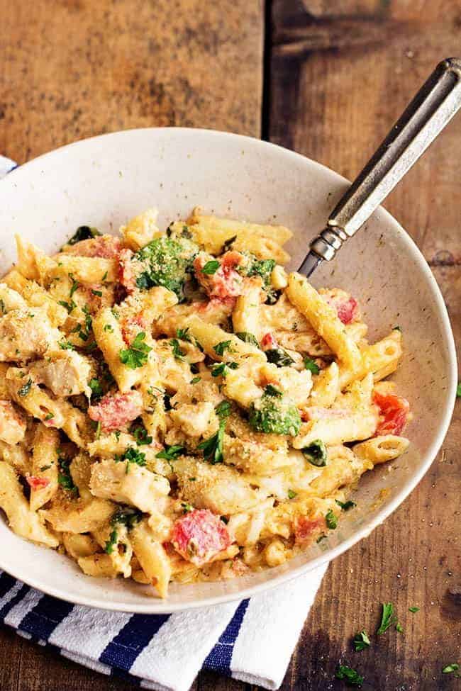 pesto alfredo chicken casserole in a white bowl.