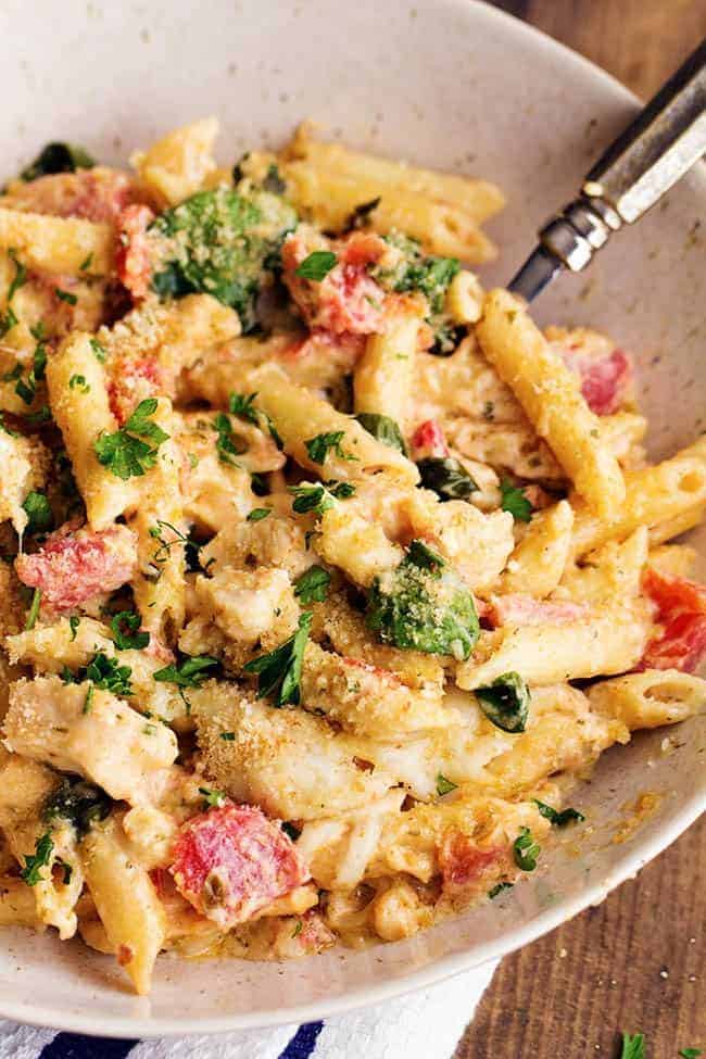 pesto alfredo chicken casserole in a white serving bowl.