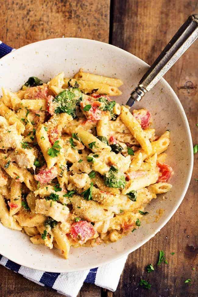 pesto chicken alfredo casserole in a white serving dish.