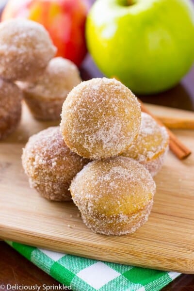 Baked Apple Cider Donut Holes stacked on a wooden counter.