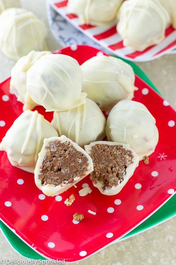 White Chocolate Almond Truffles stacked on a plate, with one cut in half to show inside.