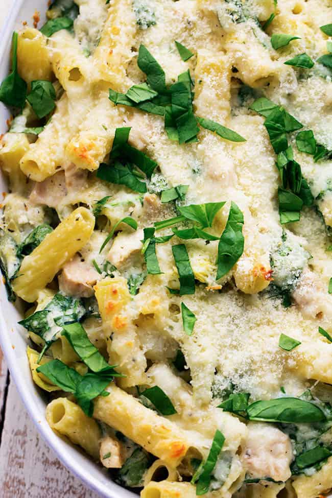 chicken spinach artichoke pasta in a white bowl.