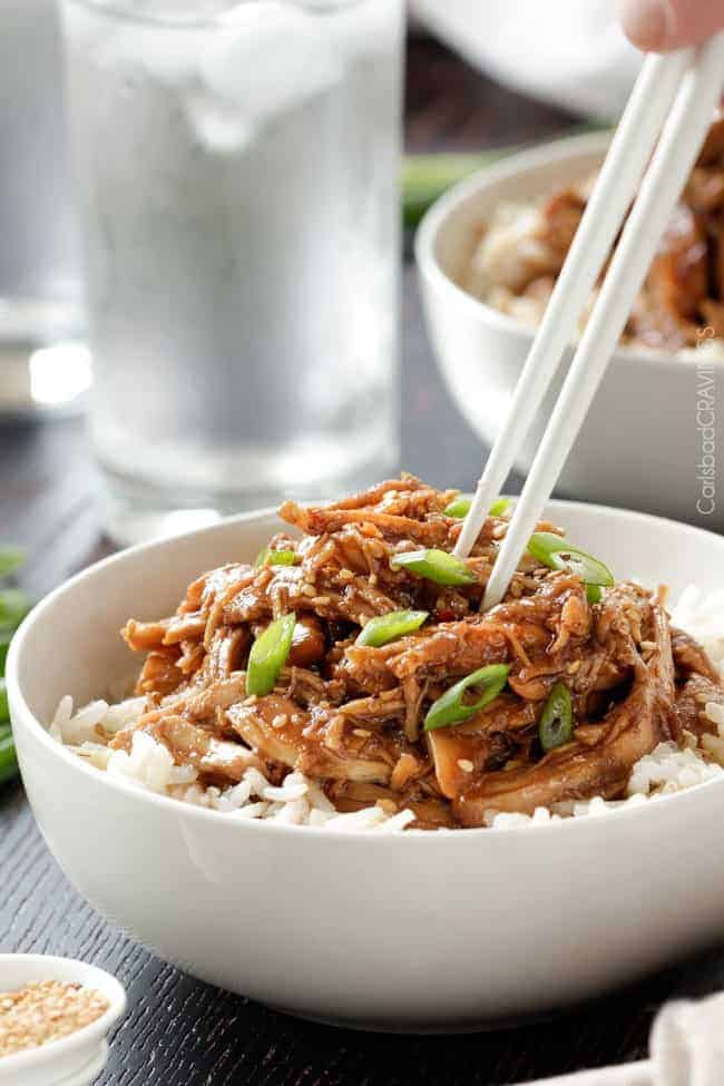 Honey soy chicken over rice in white bowl.