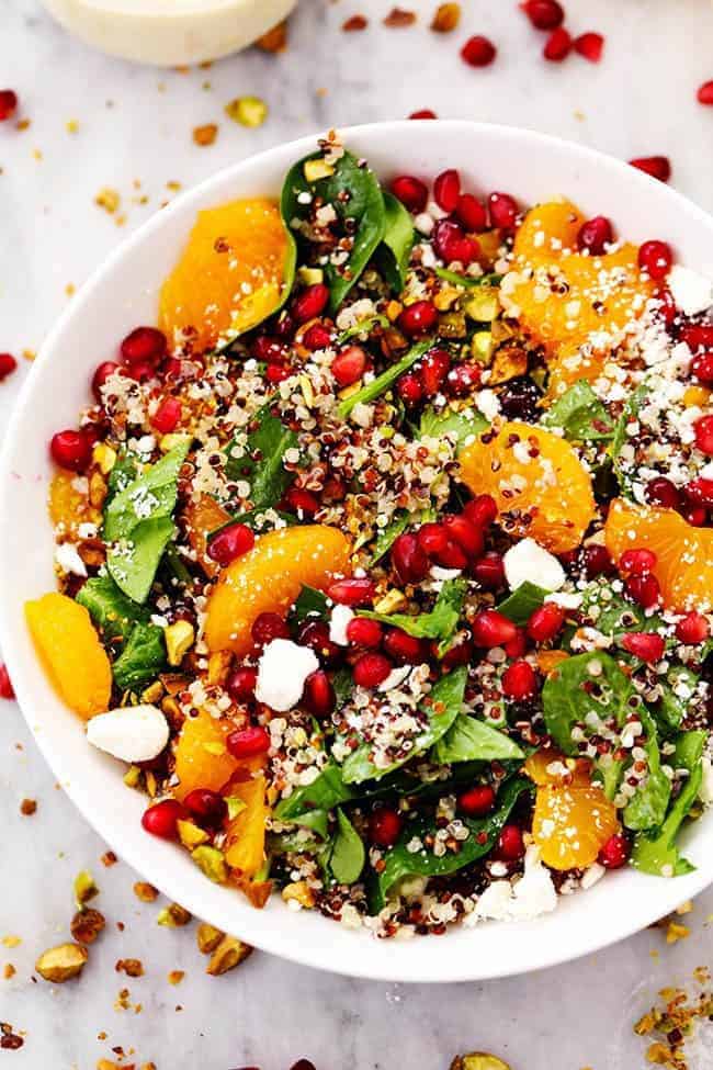 WINTER POMEGRANATE ORANGE QUINOA SALAD WITH CREAMY LEMON GREEK YOGURT DRESSING IN A WHITE BOWL.  