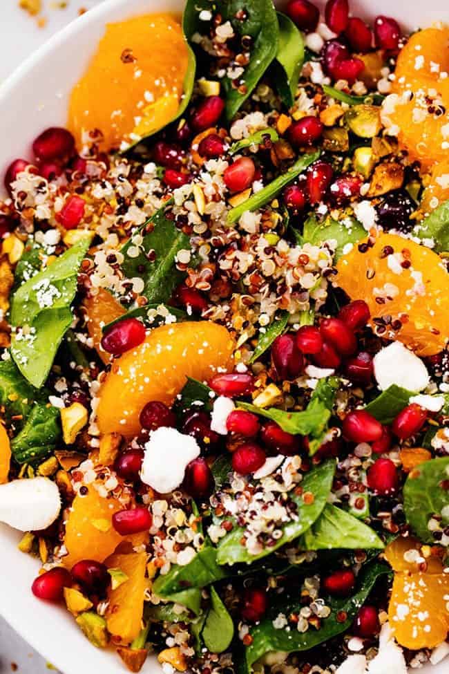 CLOSE UP OF WINTER POMEGRANATE ORANGE QUINOA SALAD WITH CREAMY LEMON GREEK YOGURT DRESSING.