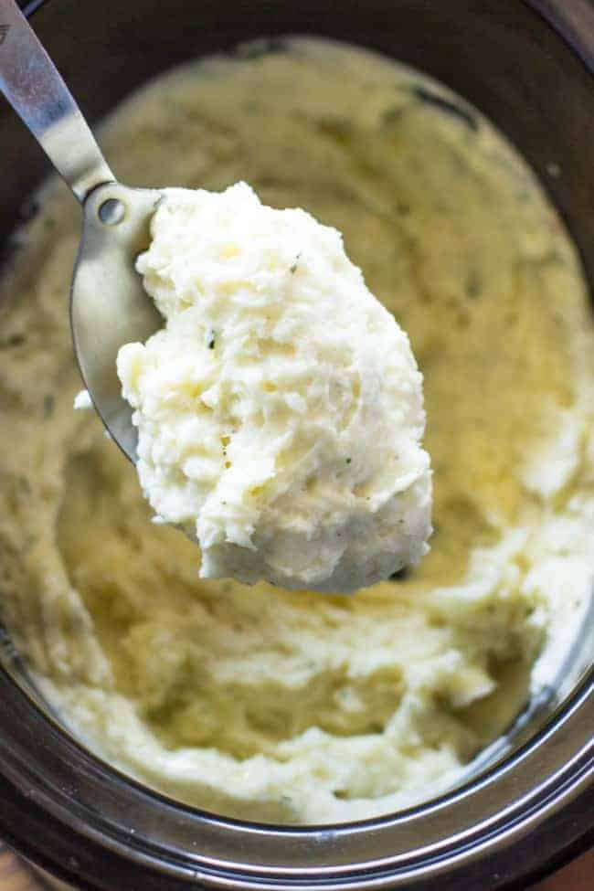 Close up photo of Slow Cooker Ranch Mashed Potatoes on a metal spoon. 