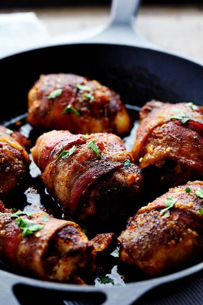 Close up photo sweet and spicy bacon wrapped chicken in a skillet.