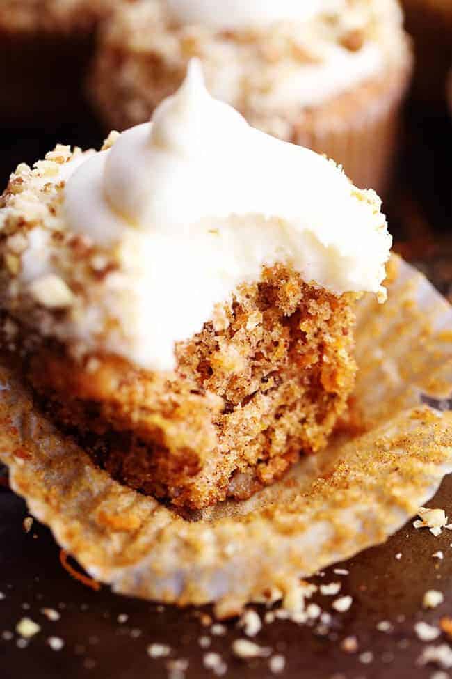 Carrot Cake Cupcakes with White Chocolate Cream Cheese Frosting with a bite taken out of it. 