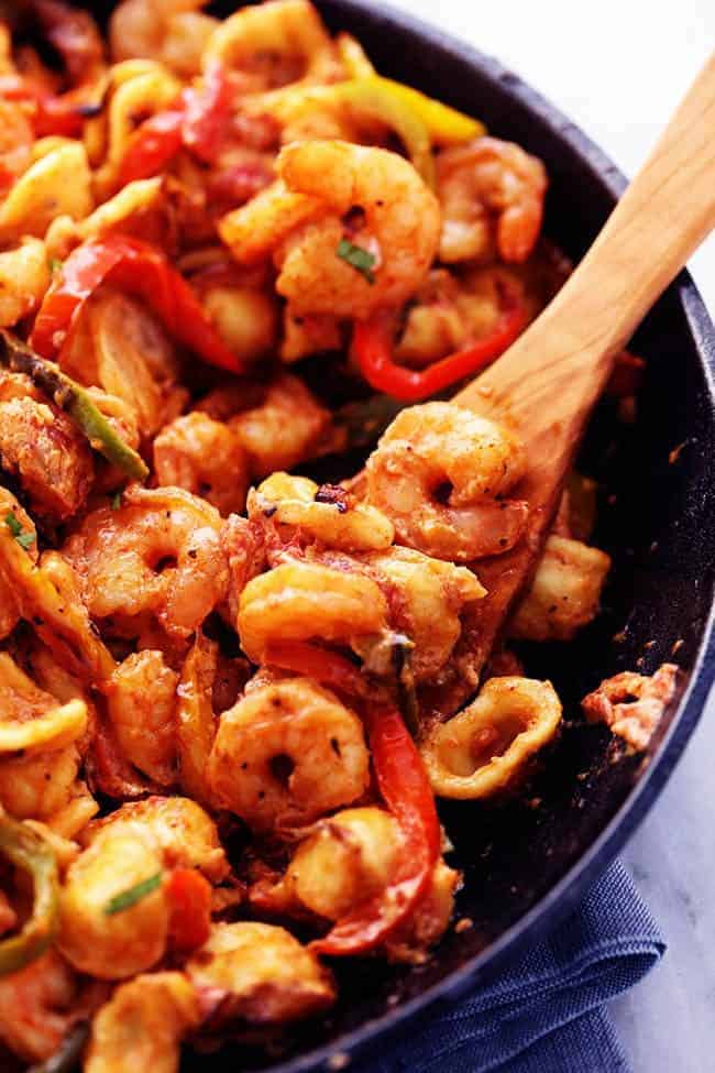 Creamy Shrimp Fajita Pasta Skillet with a wooden spoon mixing. 