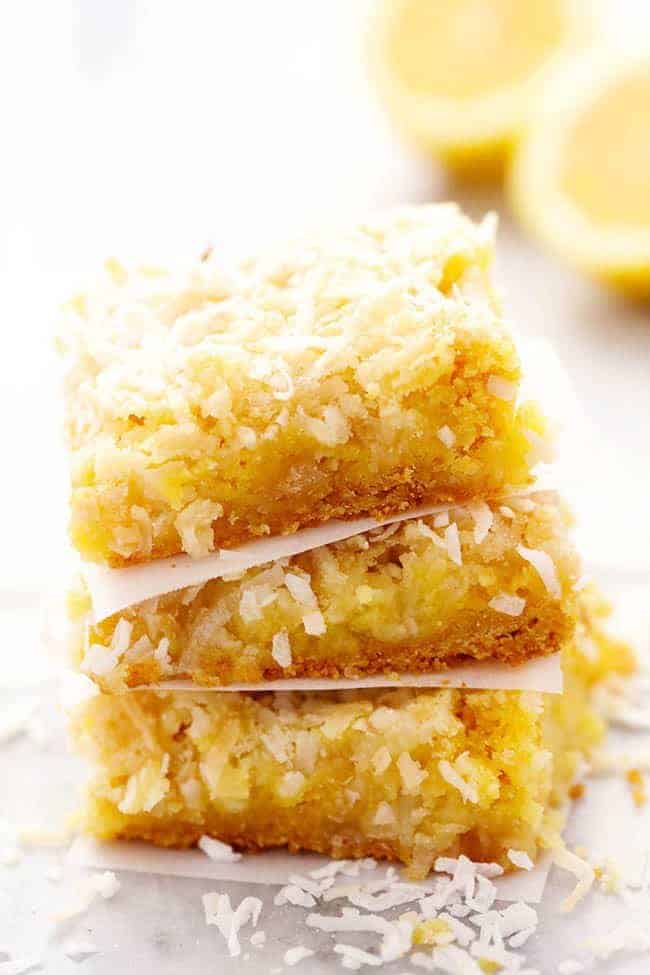 Lemon coconut butter bars stacked on top of one another.