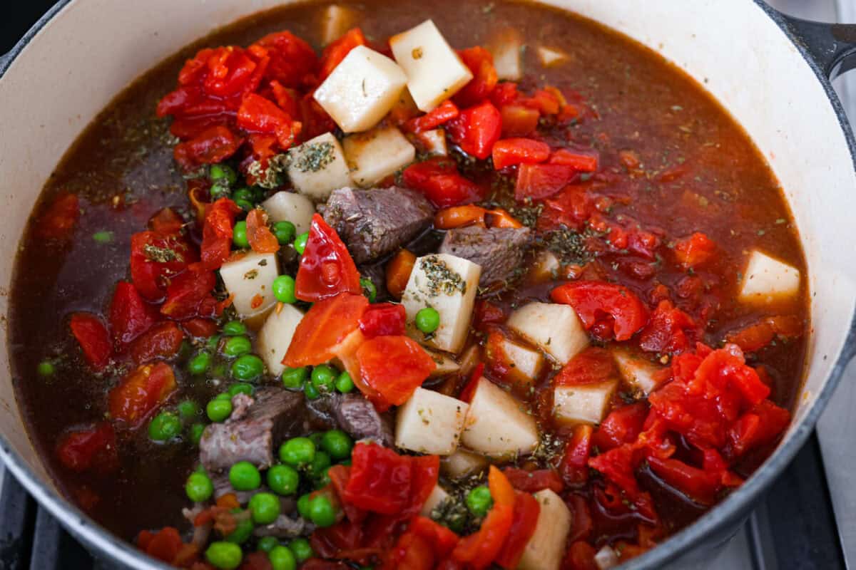 Fourth photo of all the vegetable beef soup ingredients added to the pot to simmer.