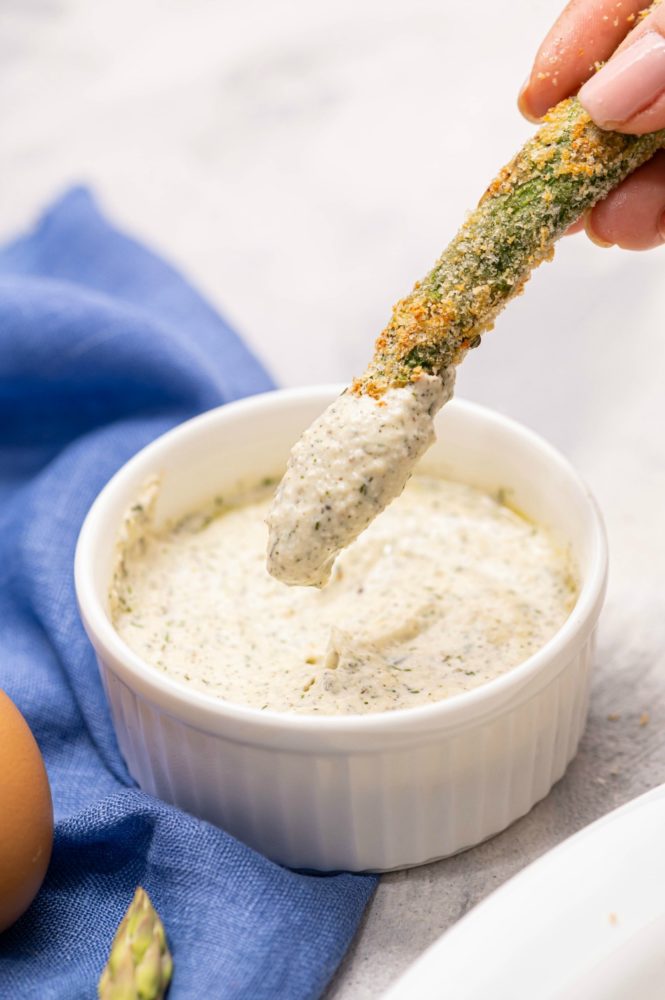 Parmesan herb asparagus fries being dipped in the creamy Greek yogurt ranch dressing.