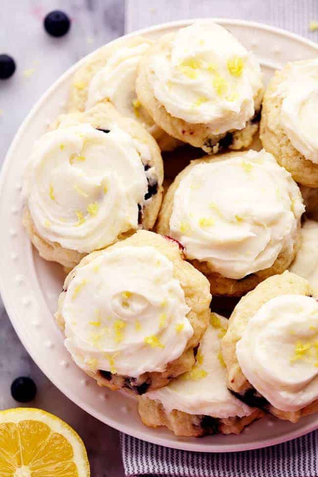 Blueberry Lemon Cookies with Lemon Cream Cheese Frosting on a white plate. 