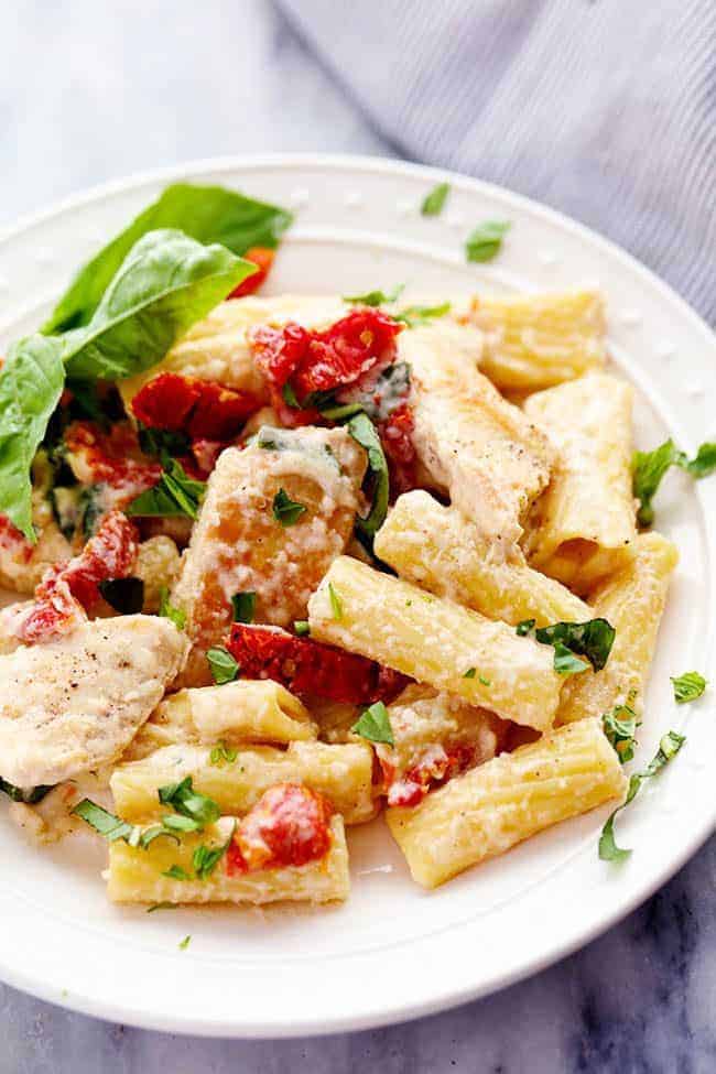 Mozzarella Chicken Pasta with Sun Dried Tomatoes on a white plate. 