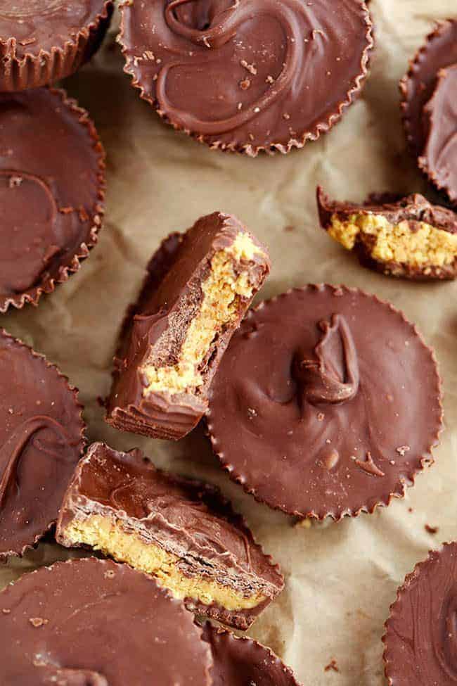 Homemade Reeses peanut butter cups with some broken in half show the middle.