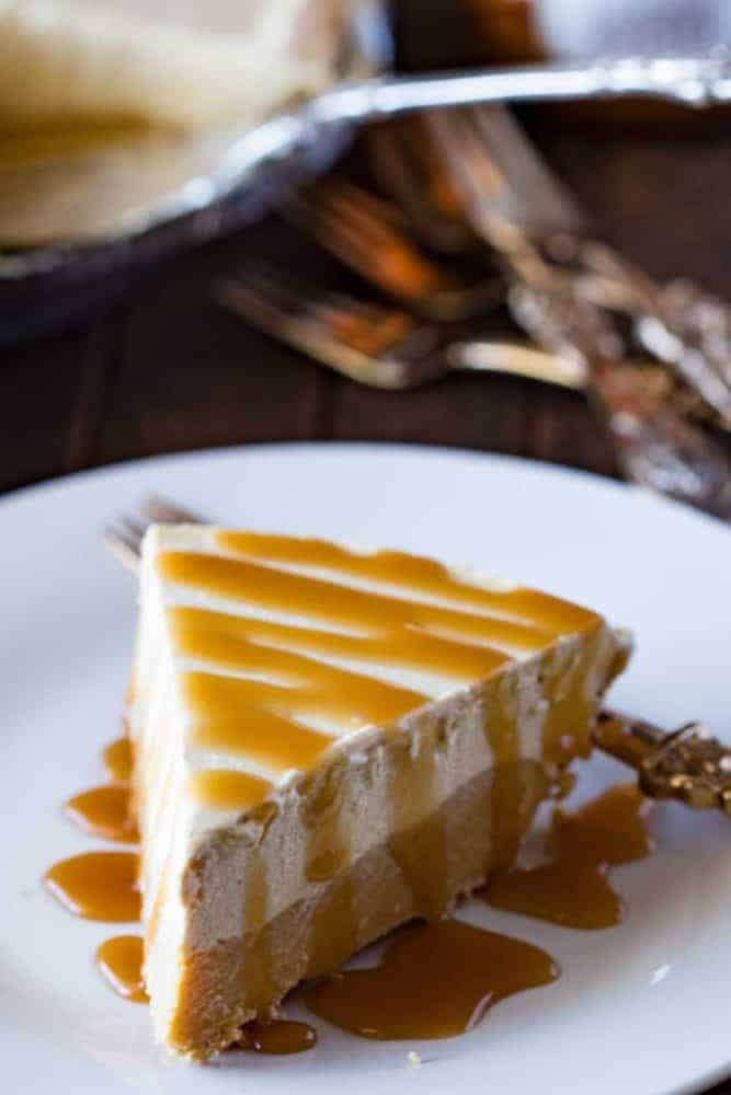 Cookie Butter Frozen Pie on a white plate with caramel drizzled on top. 