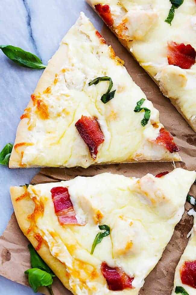 Overhead photo of Bacon Chicken Alfredo Pizza that has been sliced. 