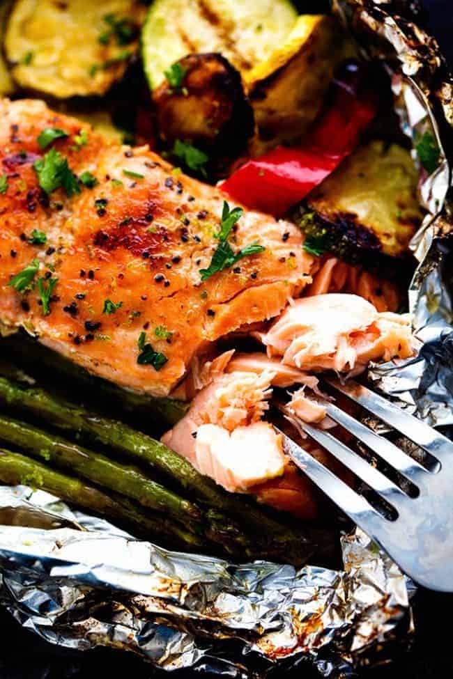 Close up photo of Lime Butter Salmon with a metal fork removing some of the salmon. 