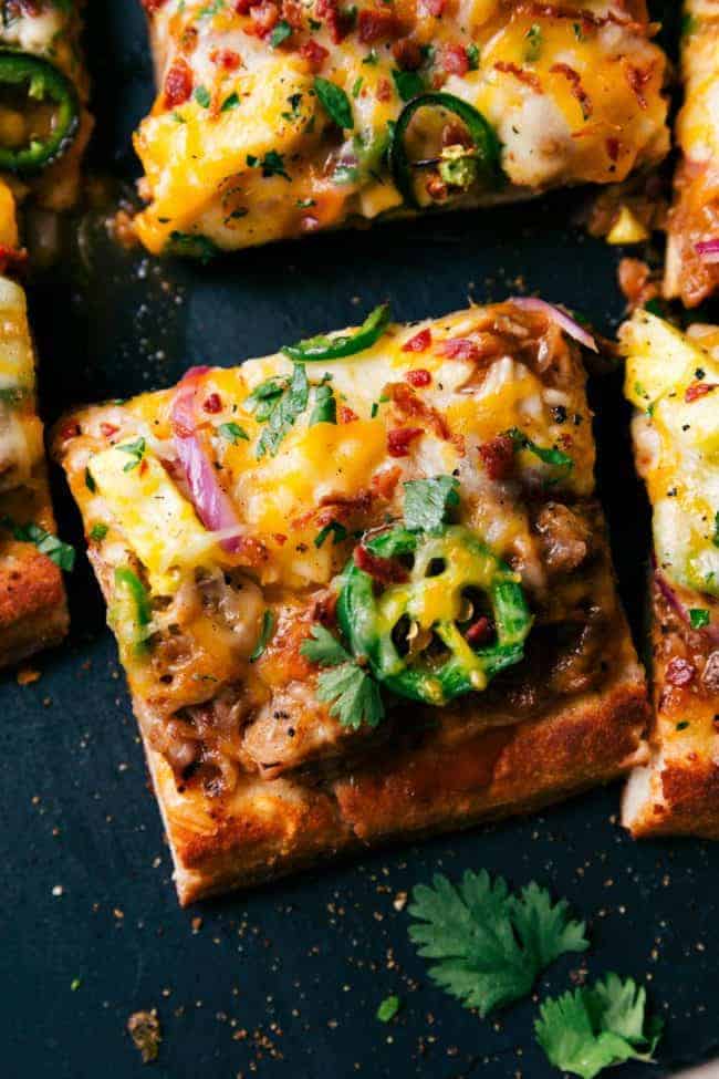 Close up photo of BBQ Pulled Pork Pizza that has been sliced into squares. 