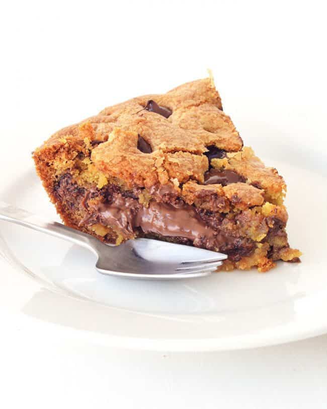 Nutella Stuffed Skillet Cookie on a white plate with a metal fork. 