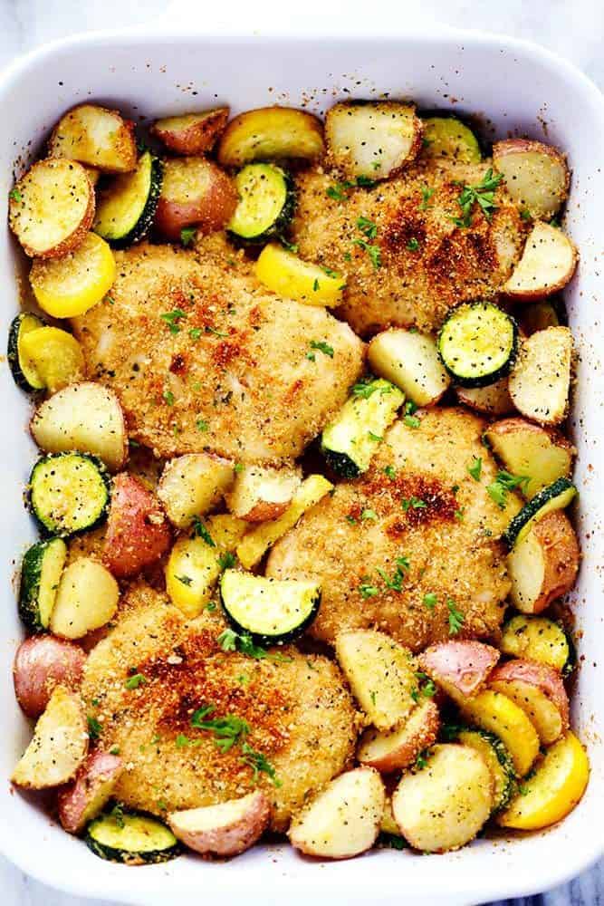 One Pan Crispy Parmesan Garlic Chicken with Vegetables in a white casserole dish. 