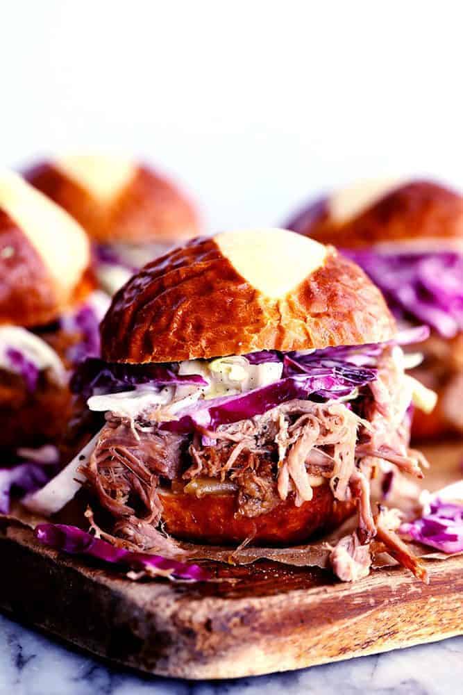 Sweet Carolina pulled pork sliders on a wooden cutting board. 