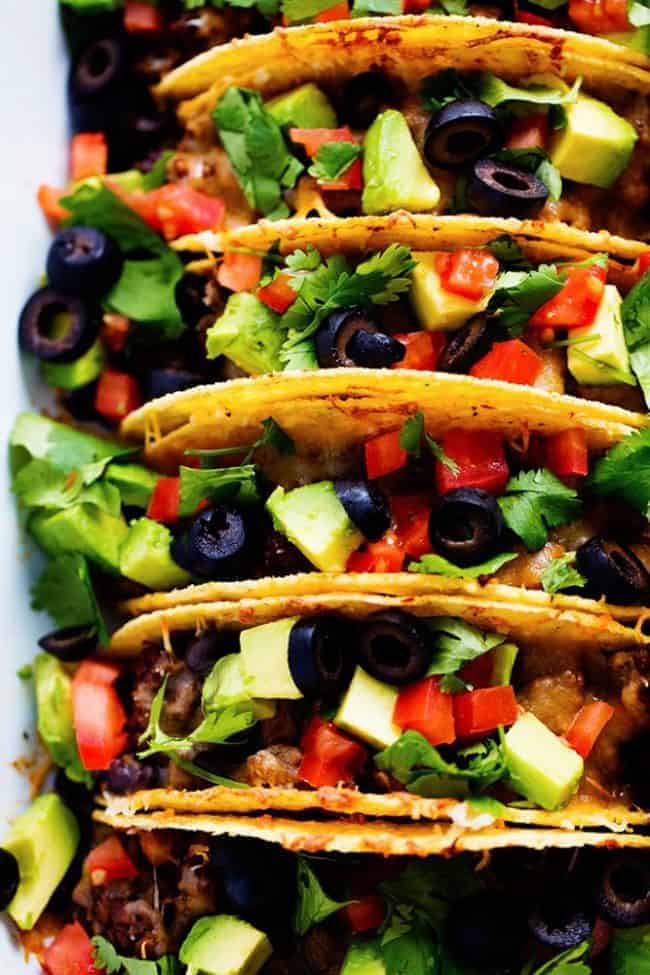 Beefy baked tacos in hard shells on a white plate. 