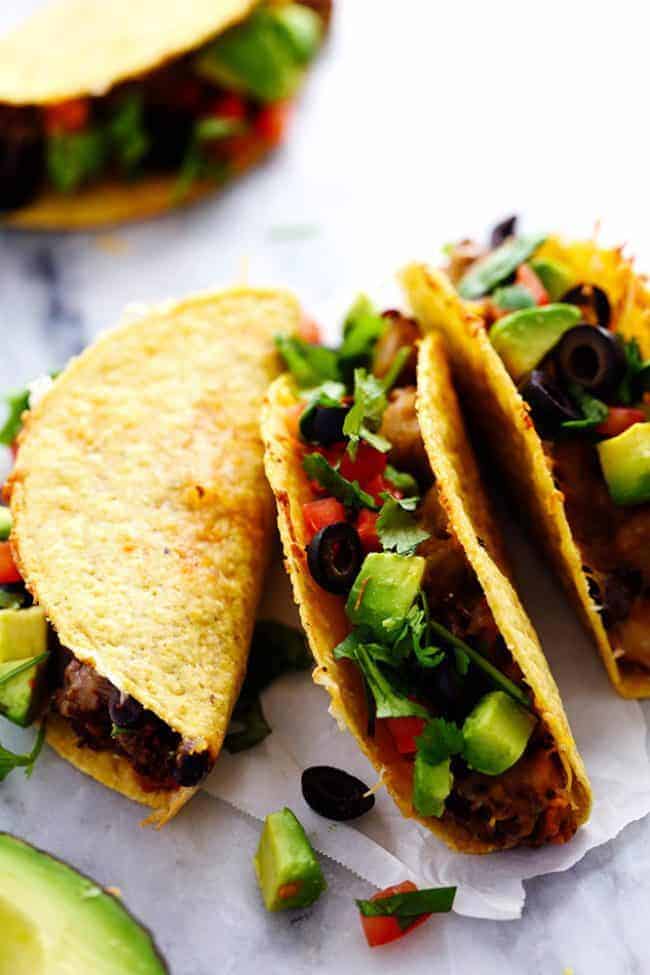 Hard shell beefy baked tacos lined up next to each other. 