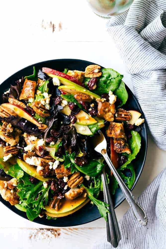 Chicken and apple salad with the Honey Dijon Vinaigrette in a black bowl with forks in the salad.