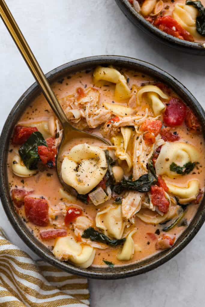 Overhead shot of a bowl of creamy Tuscan garlic tortellini soup.