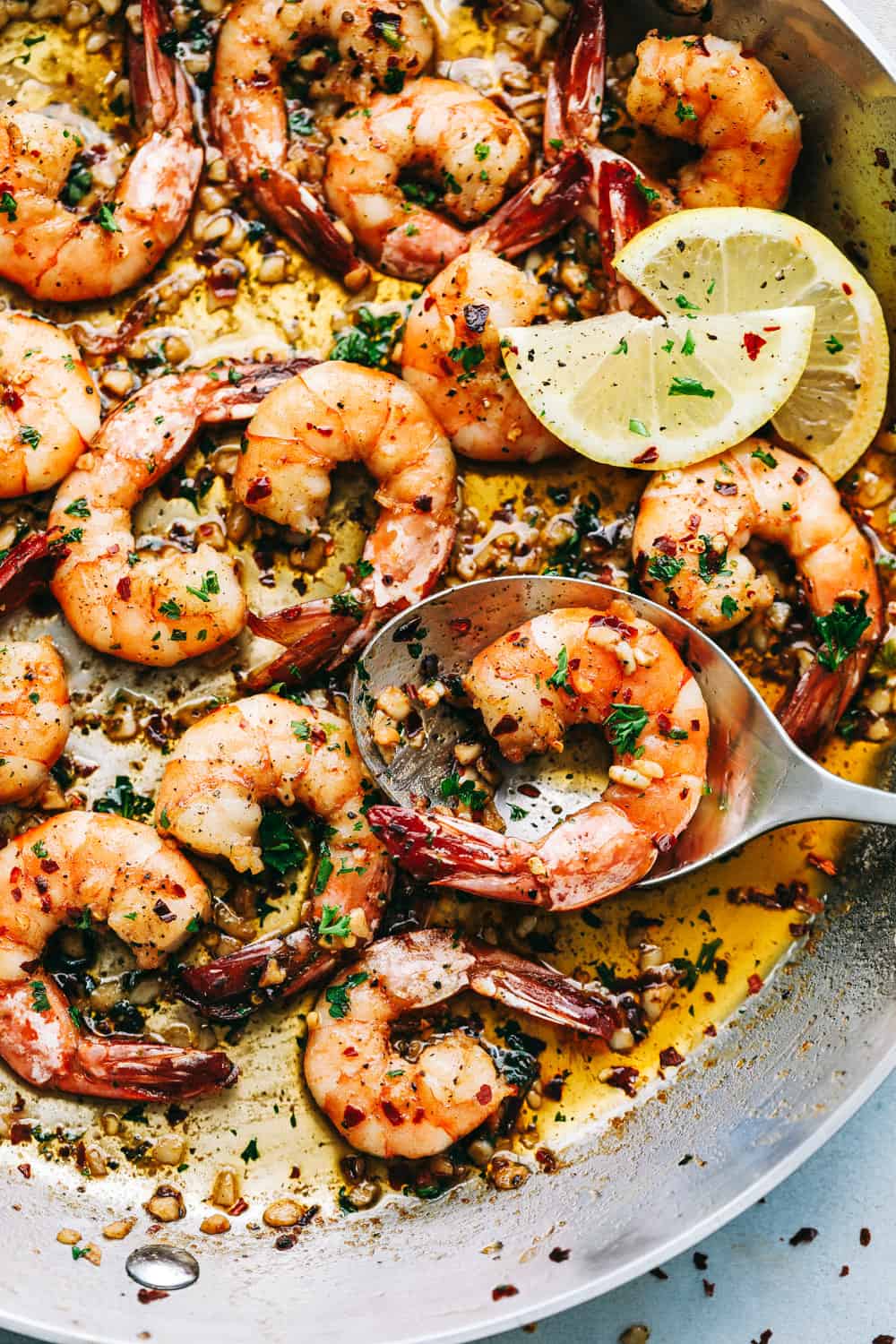 Brown Butter Spicy Garlic Shrimp being scooped into a spoon.