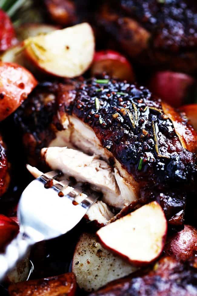 Up close photo of the glazed honey balsamic chicken being cut apart with a fork.