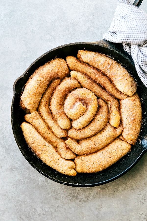 Maple bacon cinnamon roll in a skillet with no frosting.