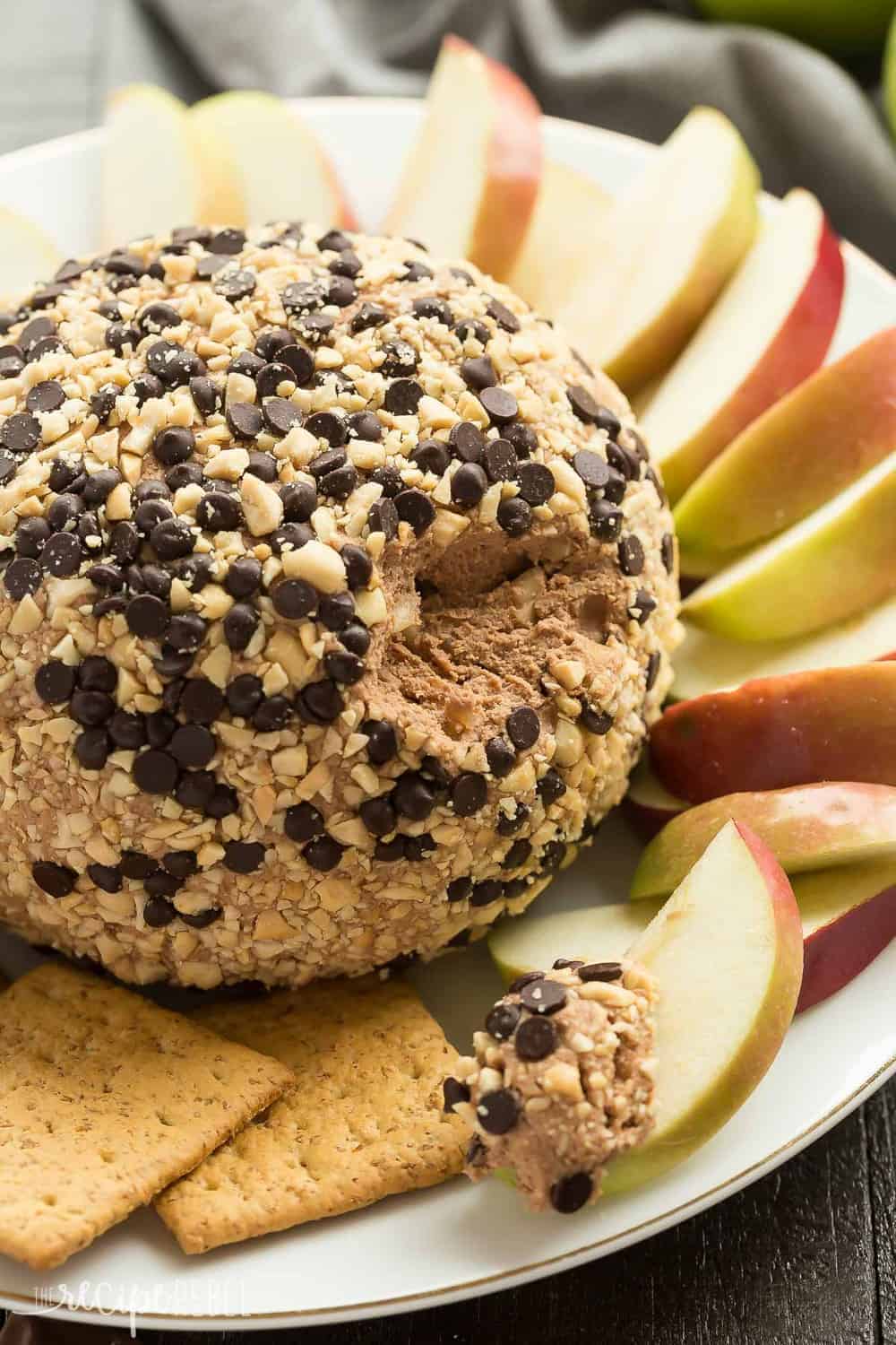 This Snickers Cheese Ball is perfect for holiday potlucks and gatherings! Loaded with caramel, chocolate and peanut butter, it's perfect served with apple slices, other fruit, and graham crackers.