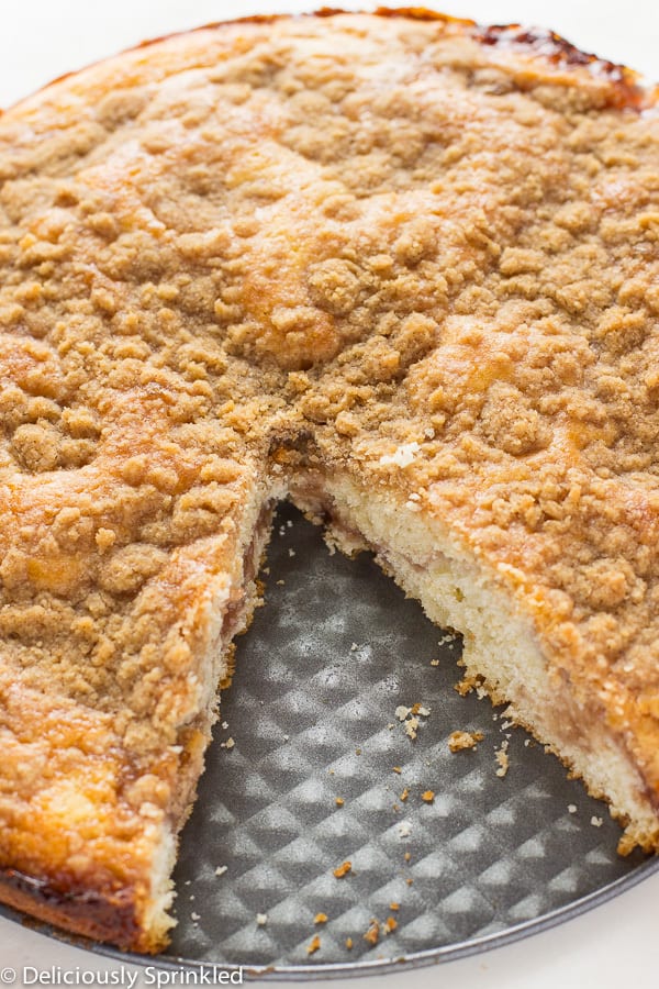 Strawberry jam crumb cake with a slice out of it.