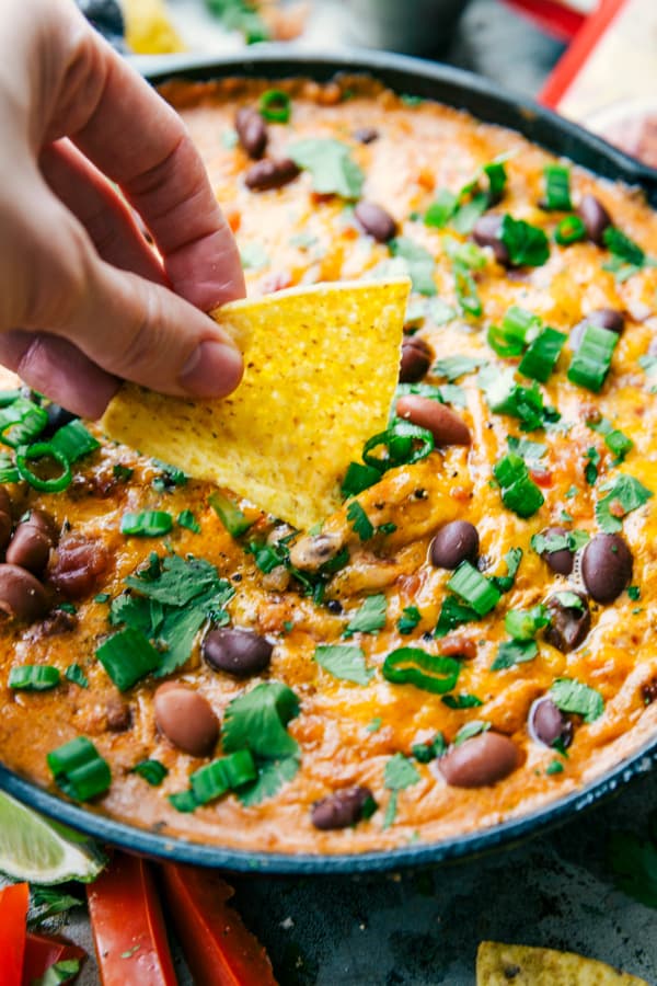 Dipping a tortilla chip into Spicy Kielbasa Chili Dip.