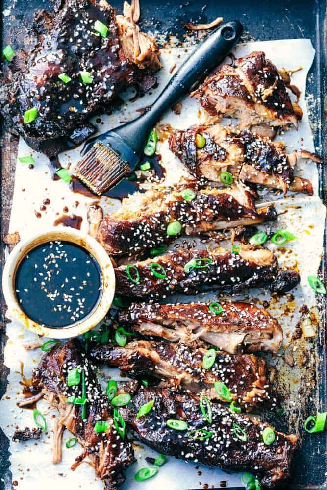 Slow Cooker Sticky Asian Ribs with Sticky Sauce and sauce with a brush to brush it on.