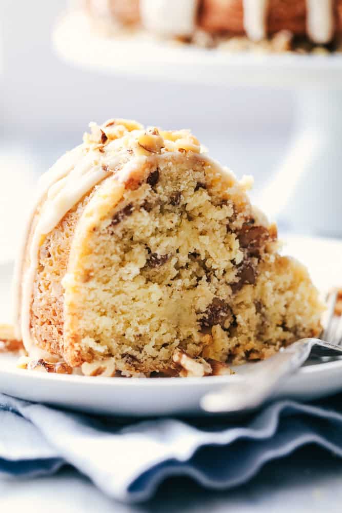 Slice of glazed Walnut Butter Cake on a white plate.