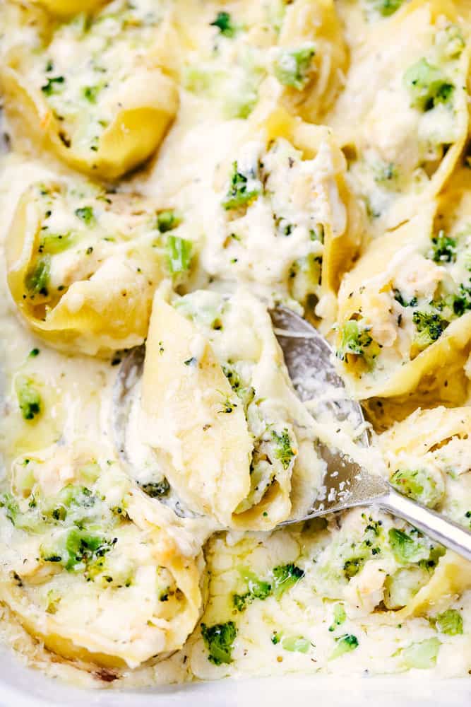 Chicken Broccoli Garlic Alfredo Shells being scooped up by a large serving spoon.