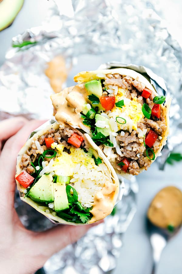 Breakfast Sausage Avocado Burritos cut in half to show the inside.