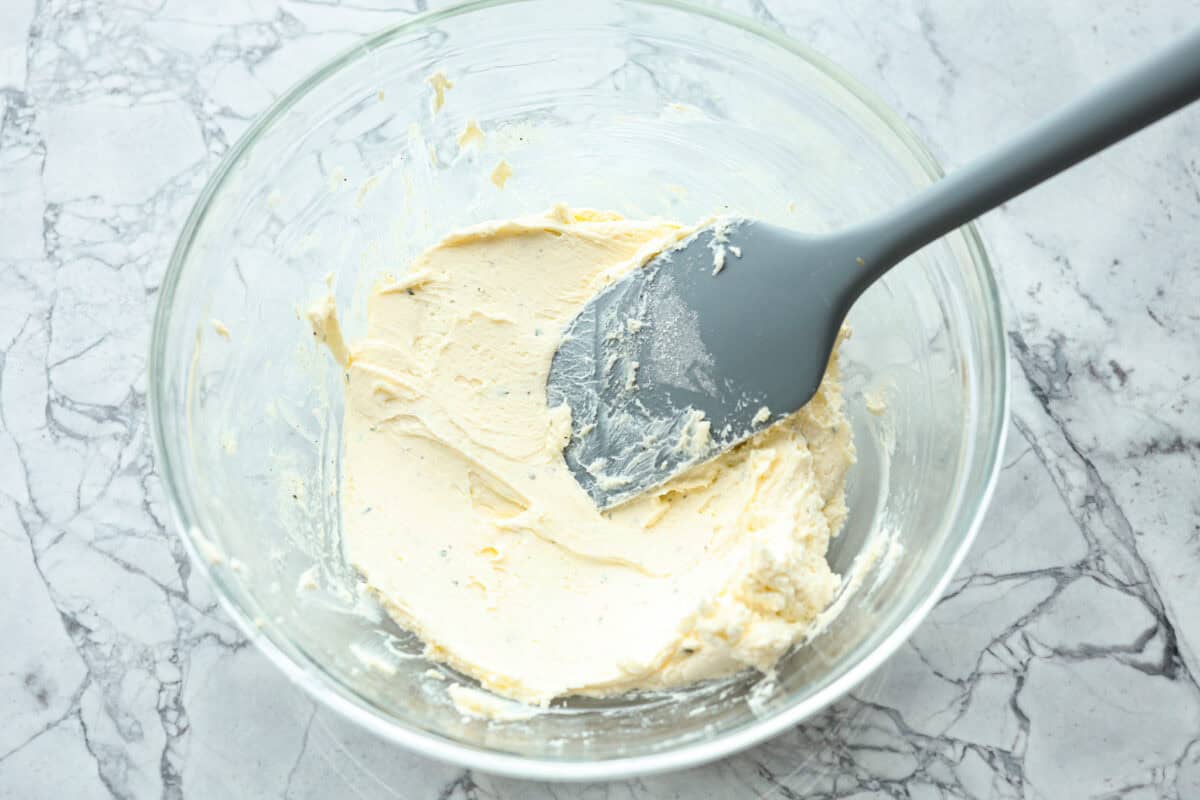 Overhead shot of cream cheese and ranch mixed in a glass bowl. 