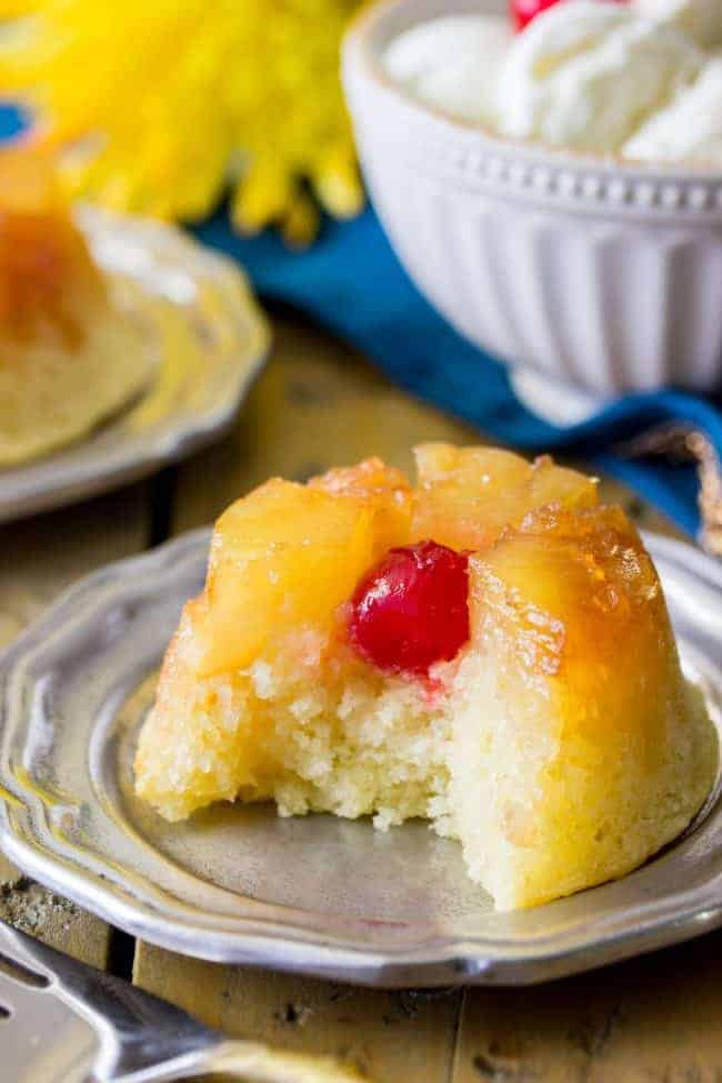 Easy, from-scratch, pineapple upside-down cupcake with a bite out to show the inside of this moist cake.